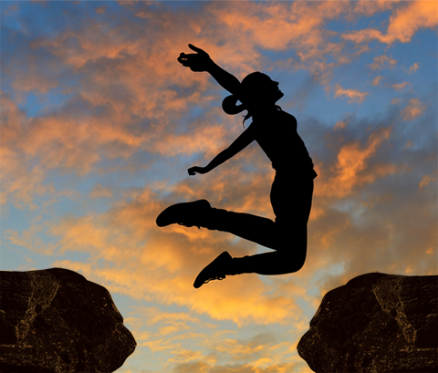 Picture of a lady jumping for a rock to another